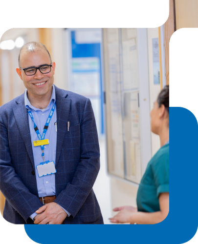 an nhs executive talks with a nurse on a ward